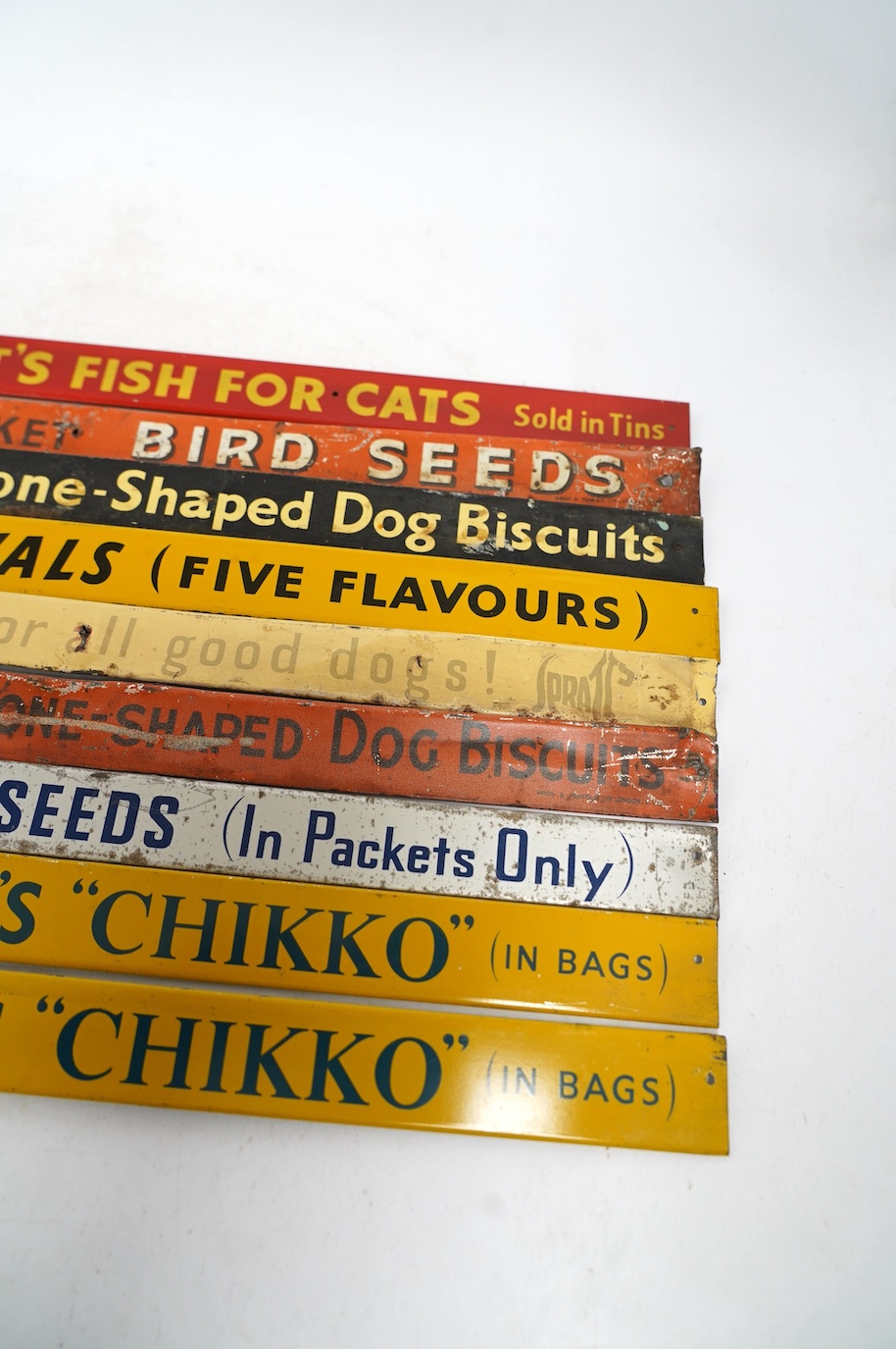 Nine mid century Spratt’s tinplate advertising shelf strips, length 52cm. Condition - poor-fair